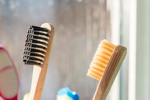 Closeup view of eco-friendly bamboo toothbrush next to window in bathroom Fotos de archivo