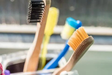 Closeup view of eco-friendly bamboo toothbrush next to window in bathroom Photos