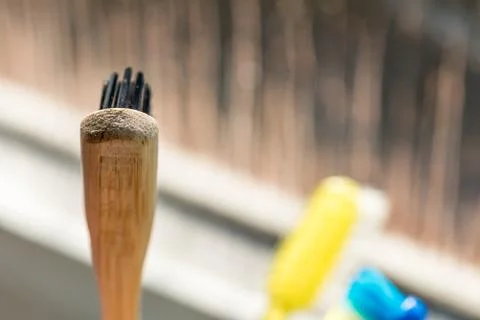 Closeup view of eco-friendly bamboo toothbrush next to window in bathroom Fotos de archivo