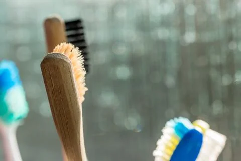Closeup view of eco-friendly bamboo toothbrush next to window in bathroom Photos
