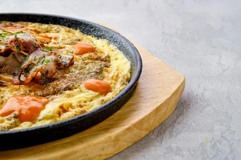 Closeup view of eggs with bell pepper and tomato baked in oven in cast-iron s Foto stock