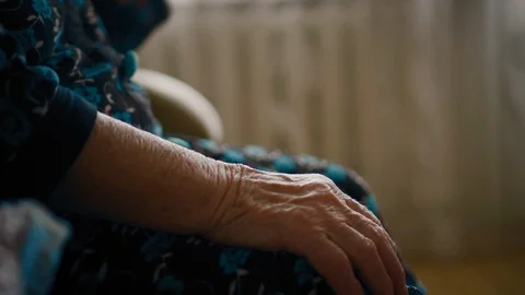 Closeup view on eldery woman's wrinkled hands on knees Stock Footage 87180383
