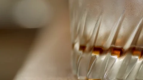 Closeup view empty misted cold glass where droped ice cubes and poured dark Vídeos de archivo 84816050