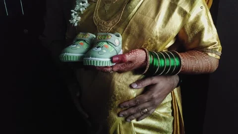 Closeup view of expecting parents holding baby shoes in traditional materni.. Stock Footage 337037780
