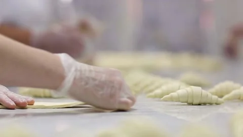 Closeup view of factory workers making croissants from dough. Stock Footage 132973055