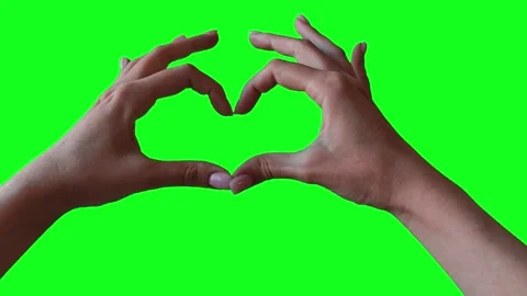 Closeup view of female hand making heart shape gesture isolated on green screen  Video stock 291393504