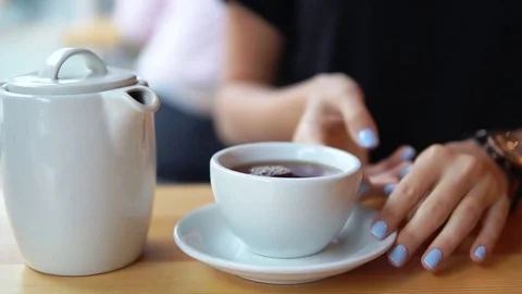 Closeup view of female hands taking a white cup with hot tea from the wooden Vídeos de archivo 79528182