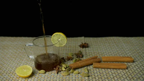 Closeup view of fresh black tea pouring in a glass cup with a lemon slice Stock-Footage 154679720