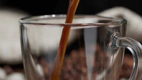 Closeup view of freshly brewed fragrant black coffee being poured into glass mug Stock Footage 146869295