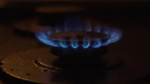 A closeup view of a gas flame dancing on a stovetop, featuring beautiful blue Stock Footage 305281886