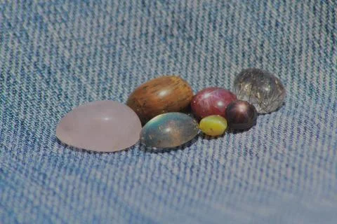Closeup view of gemstones kept on a denim cloth Stock Photos