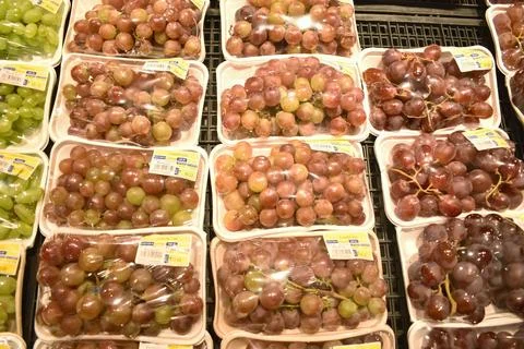 A Closeup view of Grapes packed with plastic paper in a shopping mall Stock Photos