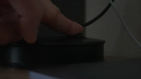 A closeup view of a hand pressing the power button on a device Vidéo 303827593