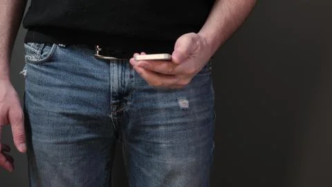 Closeup view of hand pull out a smart phone of rear jeans pocket. Close up Stock Photos