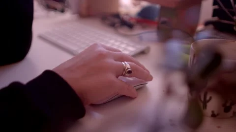 A closeup view of a hand skillfully navigating a computer mouse on a desk that h Stock Footage 295933037