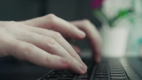 A closeup view of hands actively typing on a laptop keyboard, with beautiful Stock Footage 310206255