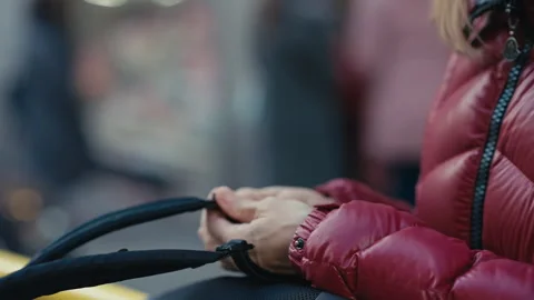 A closeup view of hands clad in a stylish puffer jacket, gently holding Stock Footage 291801121