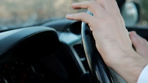 Closeup view on hands of man on steering wheel inside car Stock Footage 74694211