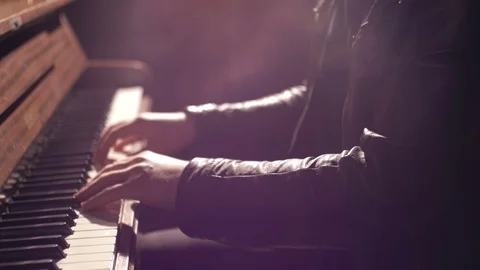 Closeup view - hands of a musician playing piano in dark studio with lens flare Stock Footage 70822262