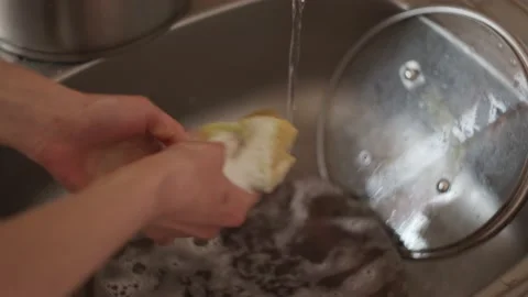 Closeup view of hands washing spoon in sink use sponge and detergent, cleaning Stock-Footage 152065597