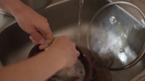 Closeup view of hands washing spoon in sink use sponge and detergent, cleaning Stock-Footage 152066428