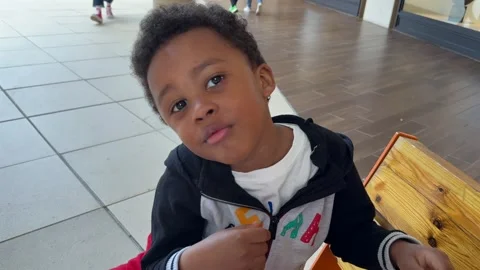 Closeup View of a Happy and Very Expressive 5.y.o Black Child Eating Candies Stock Footage 309634879