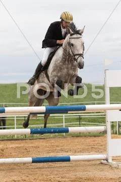 Closeup view of horseman in red jacket on a white horse Stock Photos