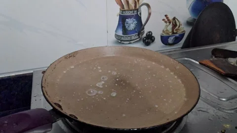Closeup view of hot pan with water droplets sizzling before making dosa batte Video stock 337037975