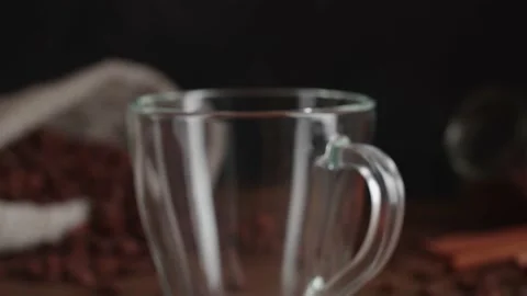 Closeup view of hot steaming black coffee being poured into glass mug Stock Footage 146861953