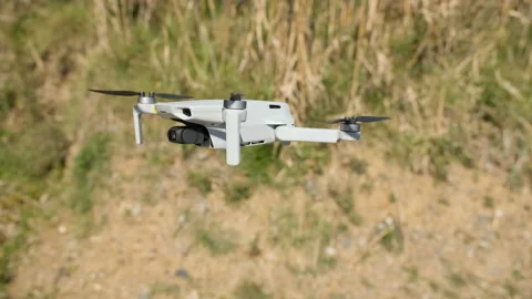 Closeup view of an hovering flying drone on windy natural scenery,new technology Stock Footage 239532626