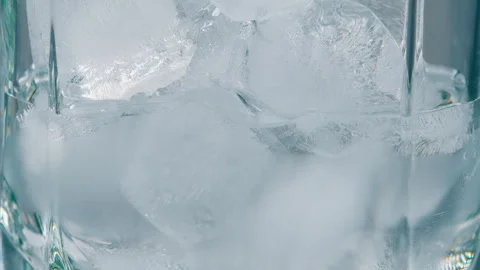 A closeup view of ice cubes resting in a glass, perfect for preparing refreshing Vidéo 303659975