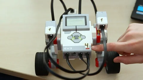 Closeup view of kid testing his just built computerized robot at robotics lesson Stock Footage 87036400