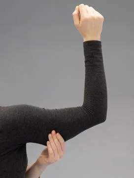 Closeup view of a lady squeezing the fat in her upper arm 스톡 사진