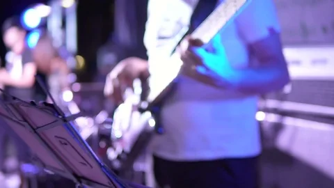 Closeup view of male hands playing bass guitar in blue neon light. Musician Stock Footage 79358536
