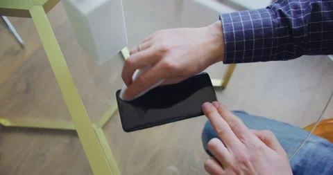 Closeup view male hands using alcohol cleaning and disinfect mobile phone screen Stock Footage 132013617