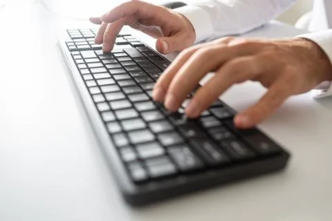 Closeup view of male hands using black computer keyboard 스톡 사진