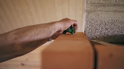 Closeup view of a man builder is measuring a brick wall with a roulette. Man is Stock Footage 90087099