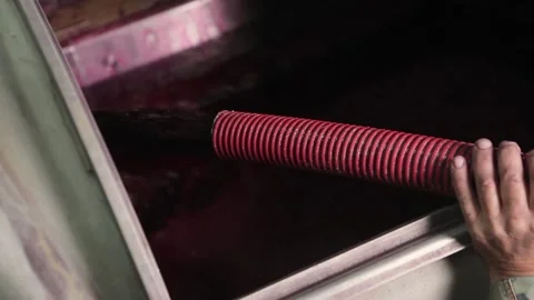 Closeup view of a man holding a pipe from which wine is pouring. Video stock 132965979