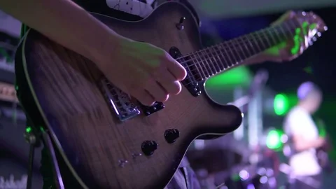 Closeup view of a man playing electric guitar on stage at the concert Stock Footage 79358427