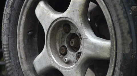 Closeup view of man turning off screws from car rear wheel Stock Footage 32495940