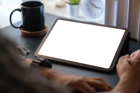 Closeup view of man using digital tablet on black wooden table. Blank scree.. Stock Photos
