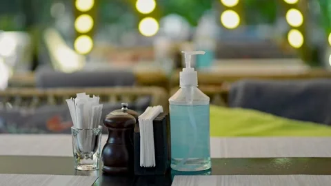 Closeup view of man using hand sanitizer on table in city restaurant indoors. Stock Footage 157231595
