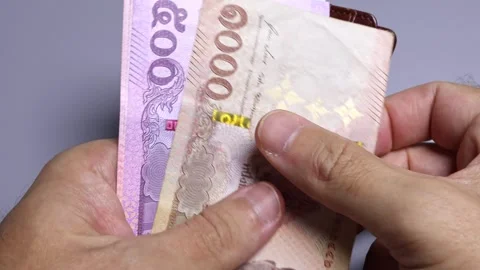 Closeup view of man's hands and wallet with thai baht banknotes. Stock Footage 302261394