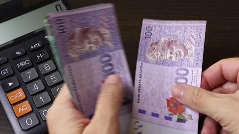 Closeup view of man's hands counting Malaysian ringgit cash money banknotes. Stock Footage 303580123
