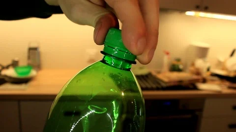 Closeup view of man's hands screwing the top from a soda bottle Stock Footage 86572041