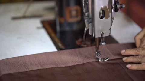A closeup of view of a manual stitching machine sewing brown cloth. Stock Footage 185039220