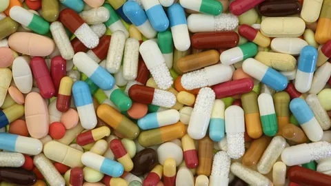 Closeup view of many different medication pills spinning Stock Footage 95477164