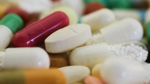 Closeup view of medication pills spinning through view Stock Footage 97823094