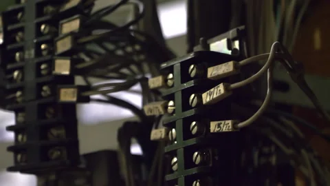 Closeup view of metallic electrical wiring hanging from a building wall Stock Footage 265113138