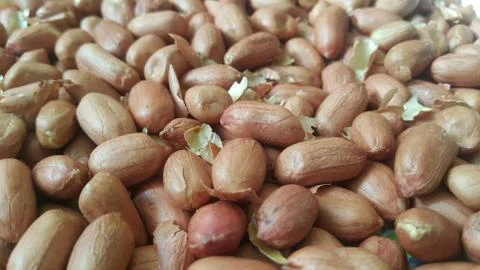 Closeup view of mixed, dried, roasted  peeled and unpeeled peanuts. A fruit f Stock Photos
